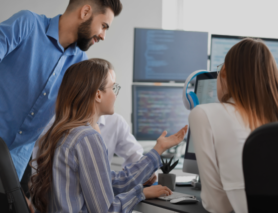 IT staffing team working on a project, looking at a computer screen